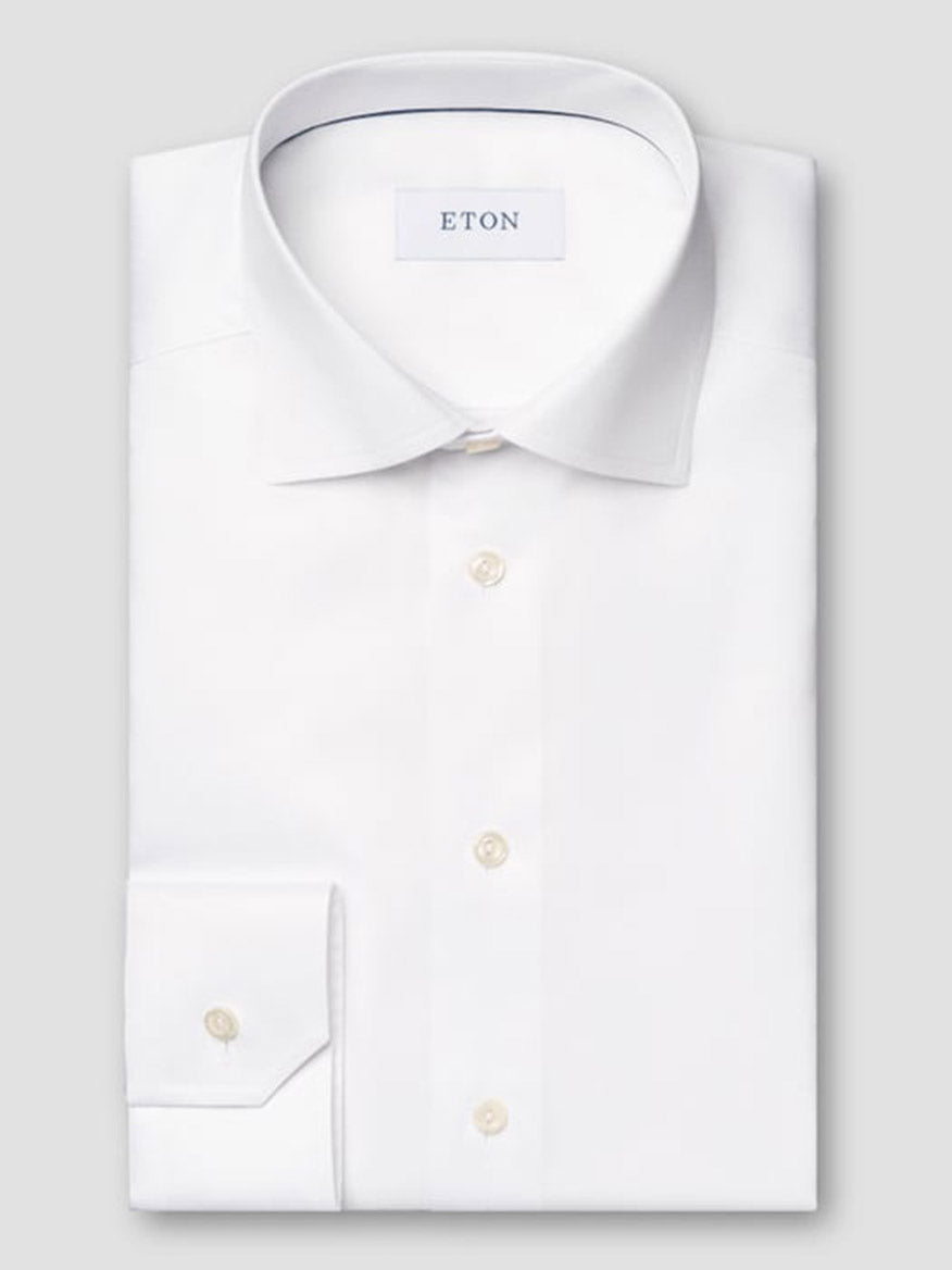 The Eton Slim Fit Solid Signature Twill Dress Shirt in White features a classic collar, single cuff, pearl buttons, and the Eton label inside the collar. Crafted from premium Signature Twill organic cotton.