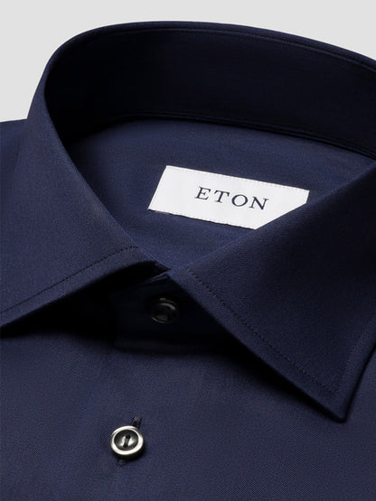 Close-up of an Eton Slim Fit Solid Signature Twill Dress Shirt in Navy Blue, crafted from organic cotton with a pointed collar and a white "ETON" label inside the collar.