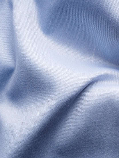 Close-up of light blue satin fabric with soft folds and a smooth, shiny texture, evoking the luxurious feel of the Eton Slim Fit Navy Details Signature Twill Dress Shirt in Light Blue.