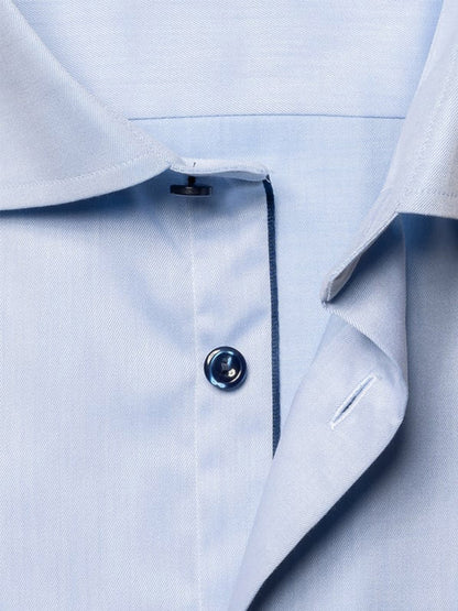 Close-up of the Eton Slim Fit Navy Details Signature Twill Dress Shirt in Light Blue, highlighting the collar, top button, and buttonhole, crafted from premium organic cotton.