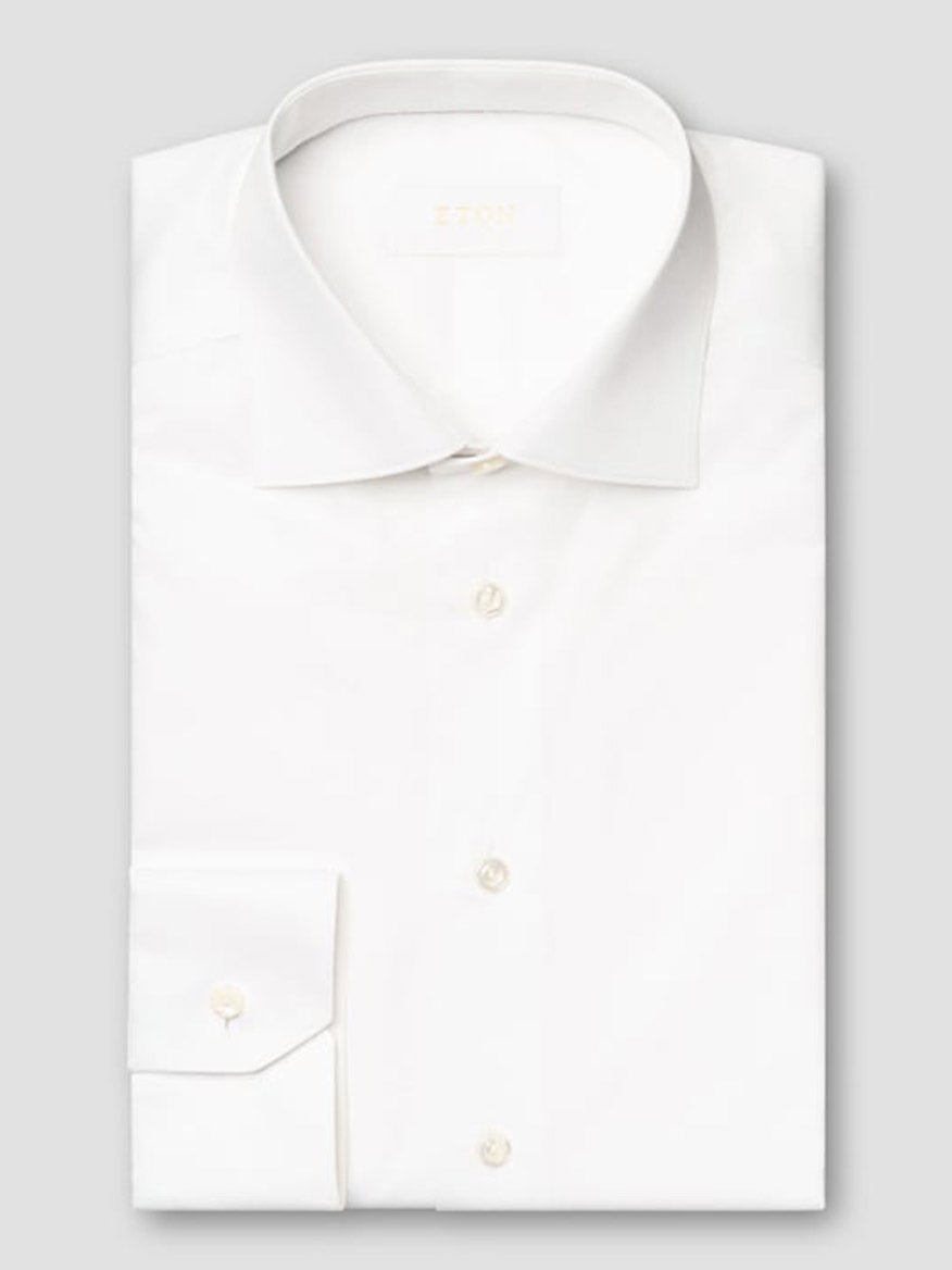 The Eton Slim Fit Solid Elevated Twill Dress Shirt in White, made from premium fabric with a classic collar and buttoned cuffs, is neatly folded and displayed against a light gray background.