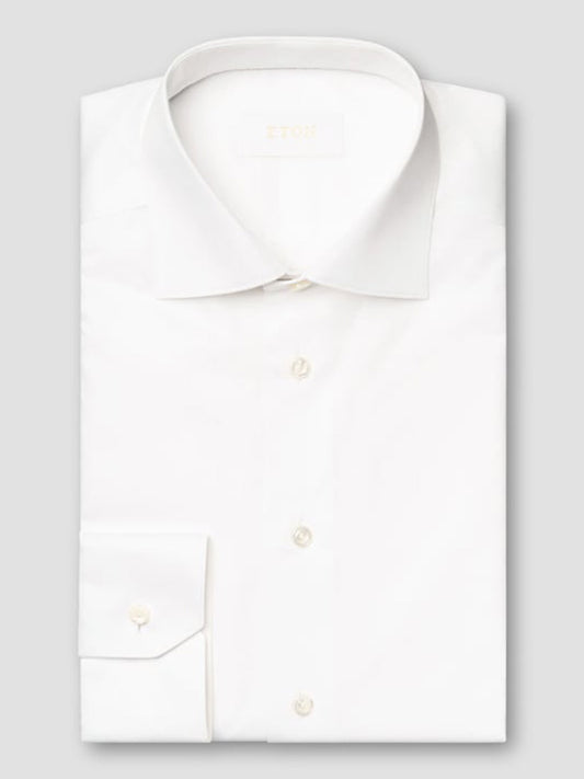 The Eton Slim Fit Solid Elevated Twill Dress Shirt in White, made from premium fabric with a classic collar and buttoned cuffs, is neatly folded and displayed against a light gray background.