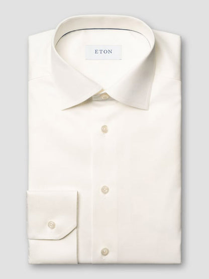 The Eton Contemporary Fit Solid Signature Twill Dress Shirt in Off-White features long sleeves, a classic collar, buttoned cuffs, and "ETON" labeling on the inner collar.