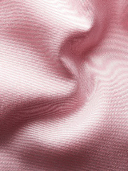 Close-up of light pink, smooth satin fabric with soft folds and gentle shadows, evoking the luxurious texture of the Eton Contemporary Fit Solid Signature Twill Dress Shirt in Pink.