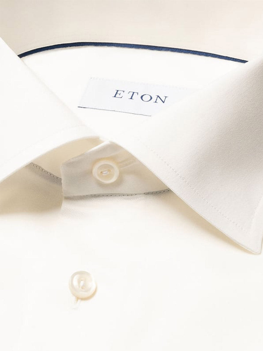 Close-up of the Eton Slim Fit Solid Signature Twill Dress Shirt in Off-White, featuring a pointed collar and visible branded label inside the neckline.
