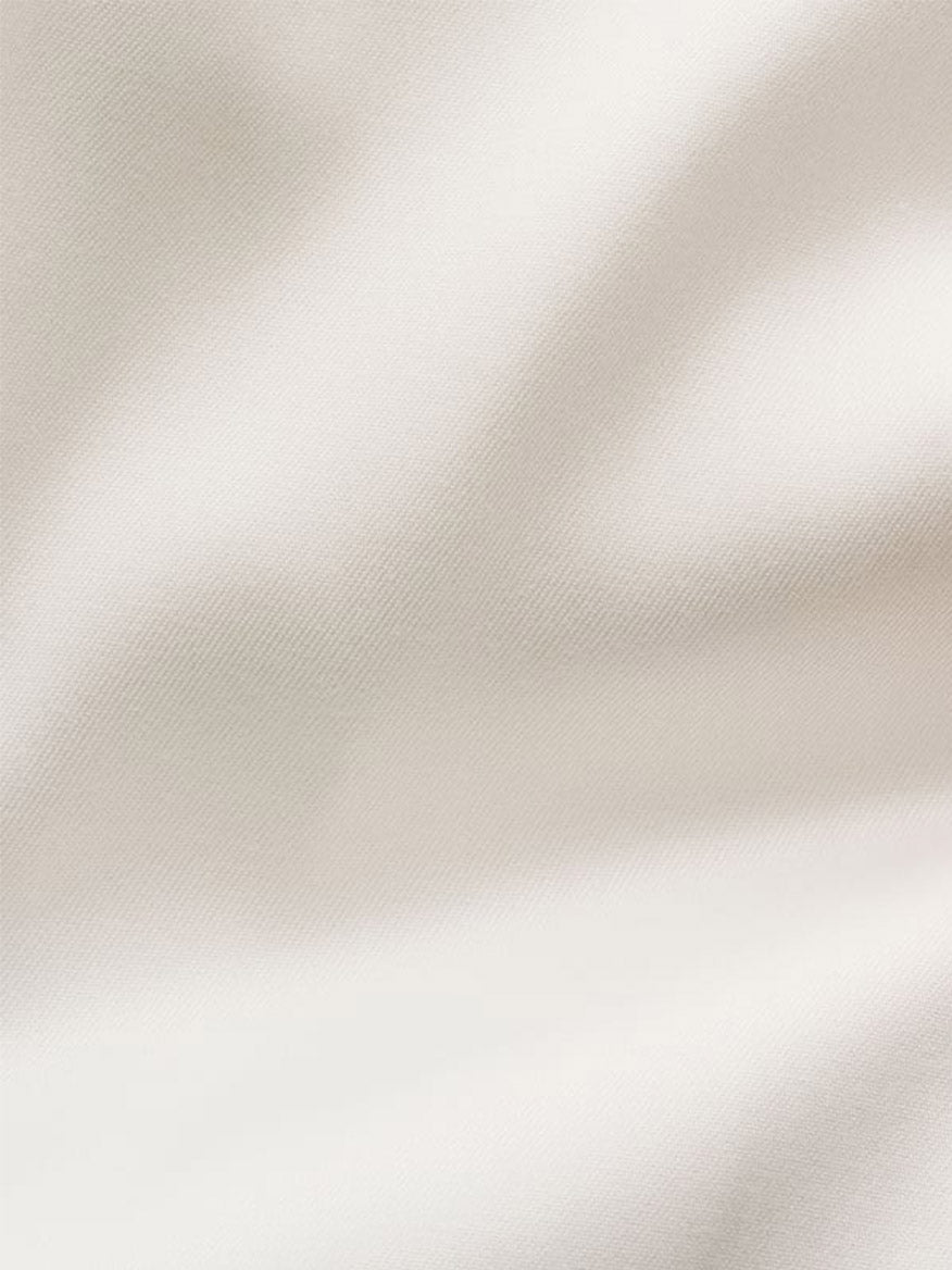 Close-up view of the smooth, off-white Eton Slim Fit Solid Signature Twill Dress Shirt fabric, featuring soft folds and a subtle texture—ideal for a refined look.