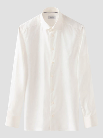 The Eton Slim Fit Solid Signature Twill Dress Shirt in Off-White, featuring a collar and long sleeves, is displayed against a light gray background.