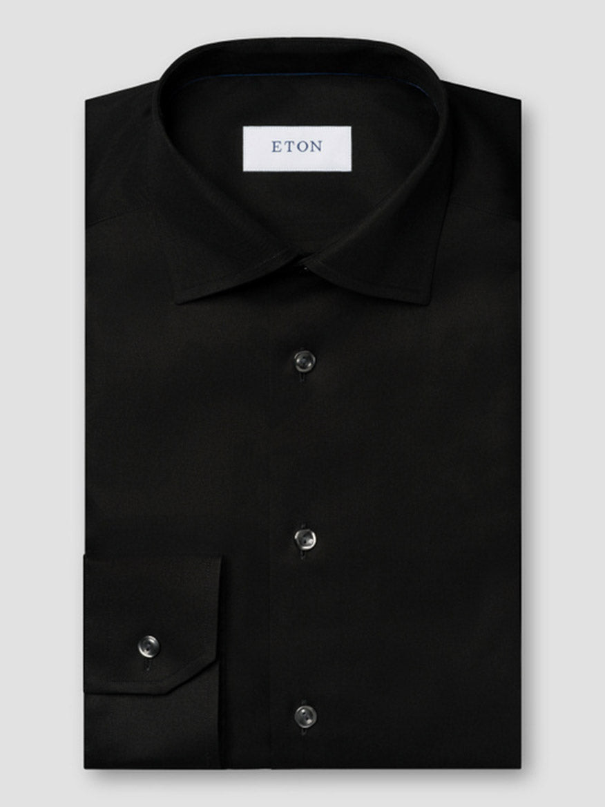 The Eton Slim Fit Solid Signature Twill Dress Shirt in Black features a cut away collar, black buttons, and premium organic Supima cotton for comfort and style. Brand label inside; tailored slim fit and crease-resistant.