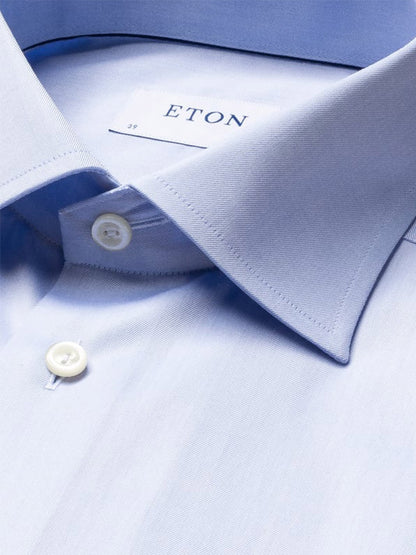 Close-up of a light blue Eton Slim Fit Solid Signature Twill Dress Shirt with French cuffs, showing the collar, buttons, and brand label inside the neckline.