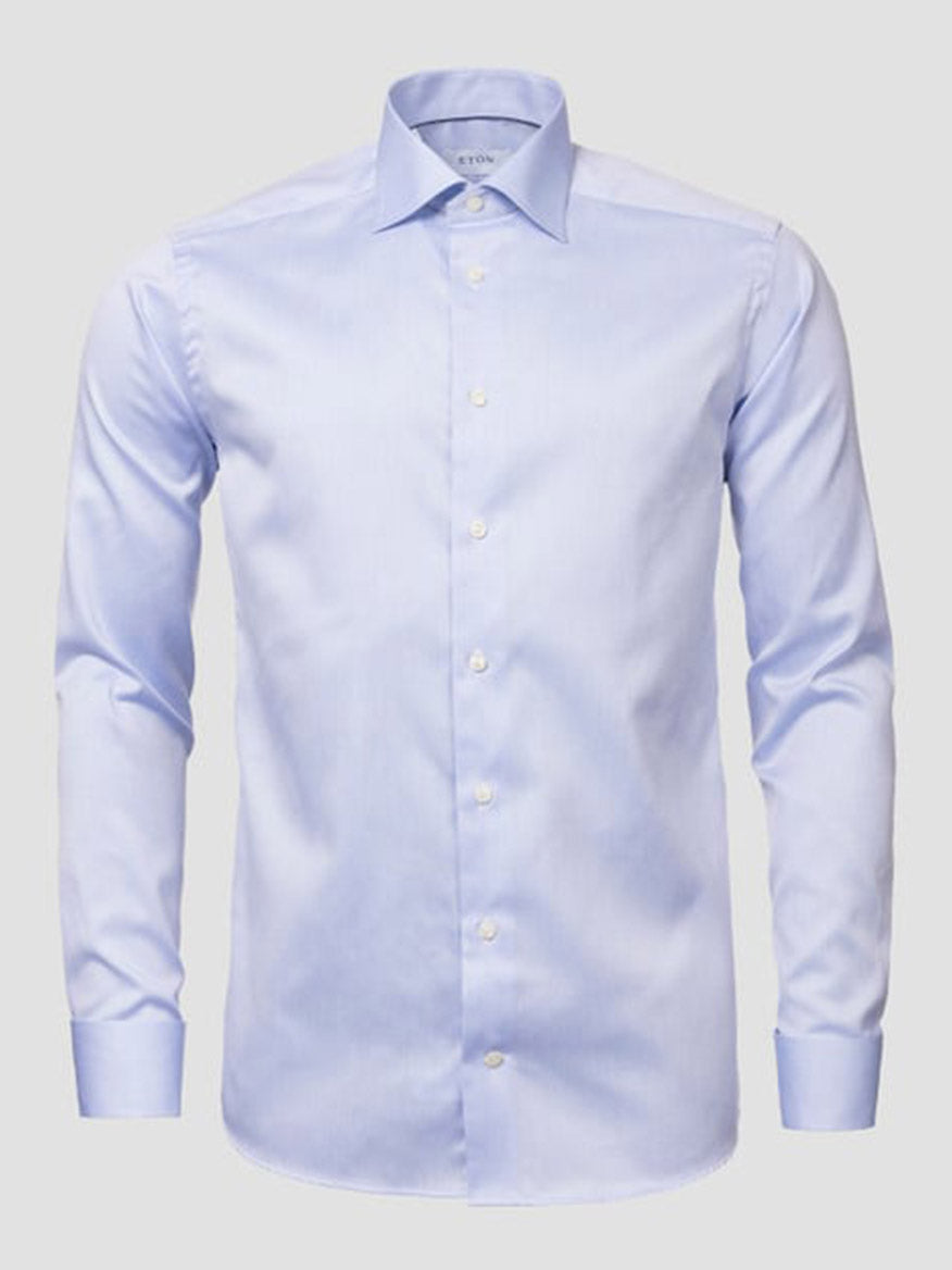 The Eton Slim Fit Solid Signature Twill Dress Shirt in light blue features French cuffs and a collar, crafted from wrinkle-free fabric and displayed against a plain gray background.