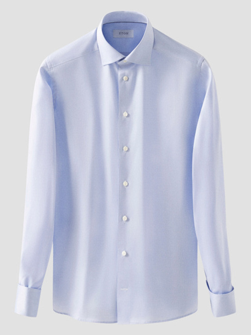 The Eton Slim Fit Solid Signature Twill Dress Shirt in Light Blue, featuring French cuffs, is shown against a plain gray background.