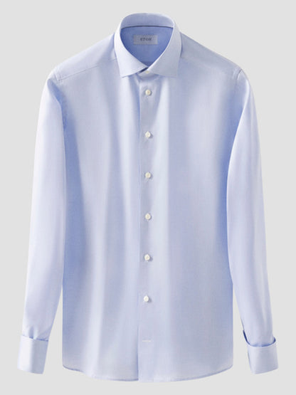 The Eton Slim Fit Solid Signature Twill Dress Shirt in Light Blue, featuring French cuffs, is shown against a plain gray background.