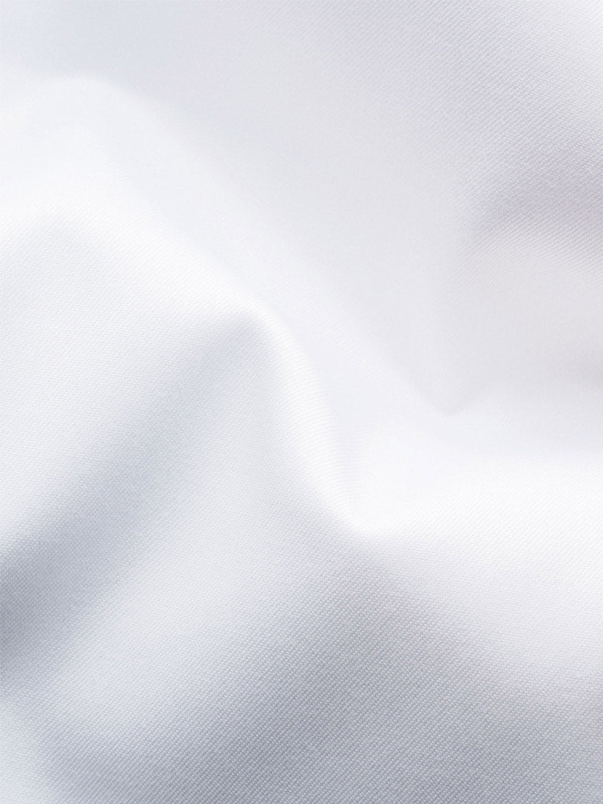 Close-up of the Eton Slim Fit Solid Signature Twill Dress Shirt in white with navy details, featuring visible texture and gentle folds, plus an extreme cut away collar.