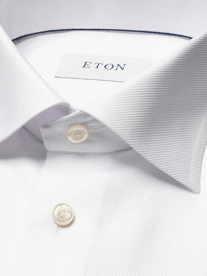 Close-up of the Eton Contemporary Fit Solid Textured Twill Dress Shirt in White, showcasing its pointed collar, French cuffs, white buttons, and signature Eton label.