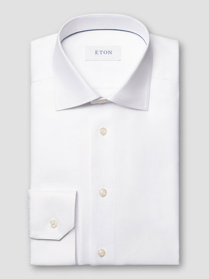 A folded white Eton Contemporary Fit Solid Textured Twill Dress Shirt with a classic collar and single cuff, featuring an "ETON" label on the inside collar.