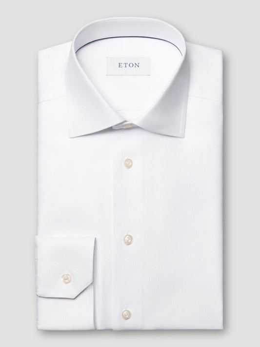 A folded white Eton Contemporary Fit Solid Textured Twill Dress Shirt with a classic collar and single cuff, featuring an "ETON" label on the inside collar.