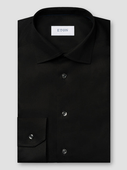 The Eton Contemporary Fit Black Signature Twill Dress Shirt features a spread collar, buttoned cuffs, and a white "ETON" label inside the collar. This wrinkle-free shirt offers style and convenience for modern professionals.
