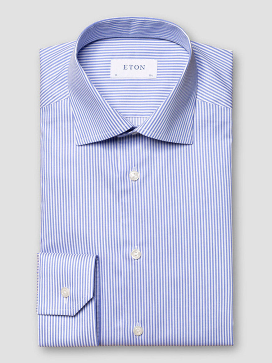 The Eton Contemporary Fit Striped Fine Twill Dress Shirt in Light Blue features blue and white stripes, a classic collar, and button front—perfect for business attire, displayed neatly folded against a plain grey background.