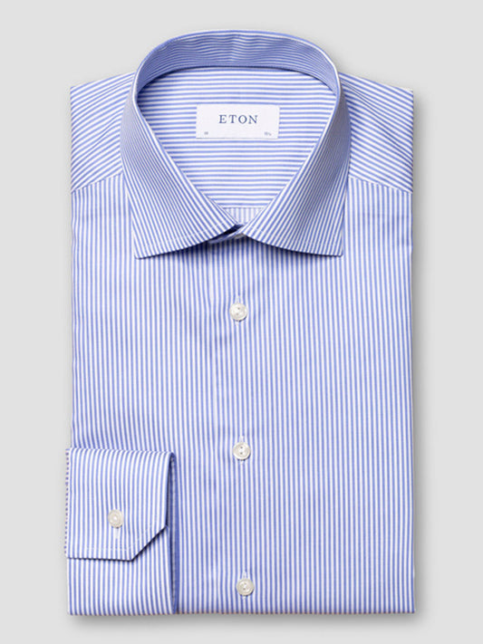 The Eton Contemporary Fit Striped Fine Twill Dress Shirt in Light Blue features blue and white stripes, a classic collar, and button front—perfect for business attire, displayed neatly folded against a plain grey background.