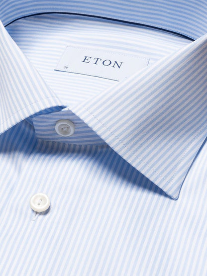 A close-up of the Eton Slim Fit Striped Fine Twill Dress Shirt in Light Blue with a cut away collar, showing the label and two white buttons.