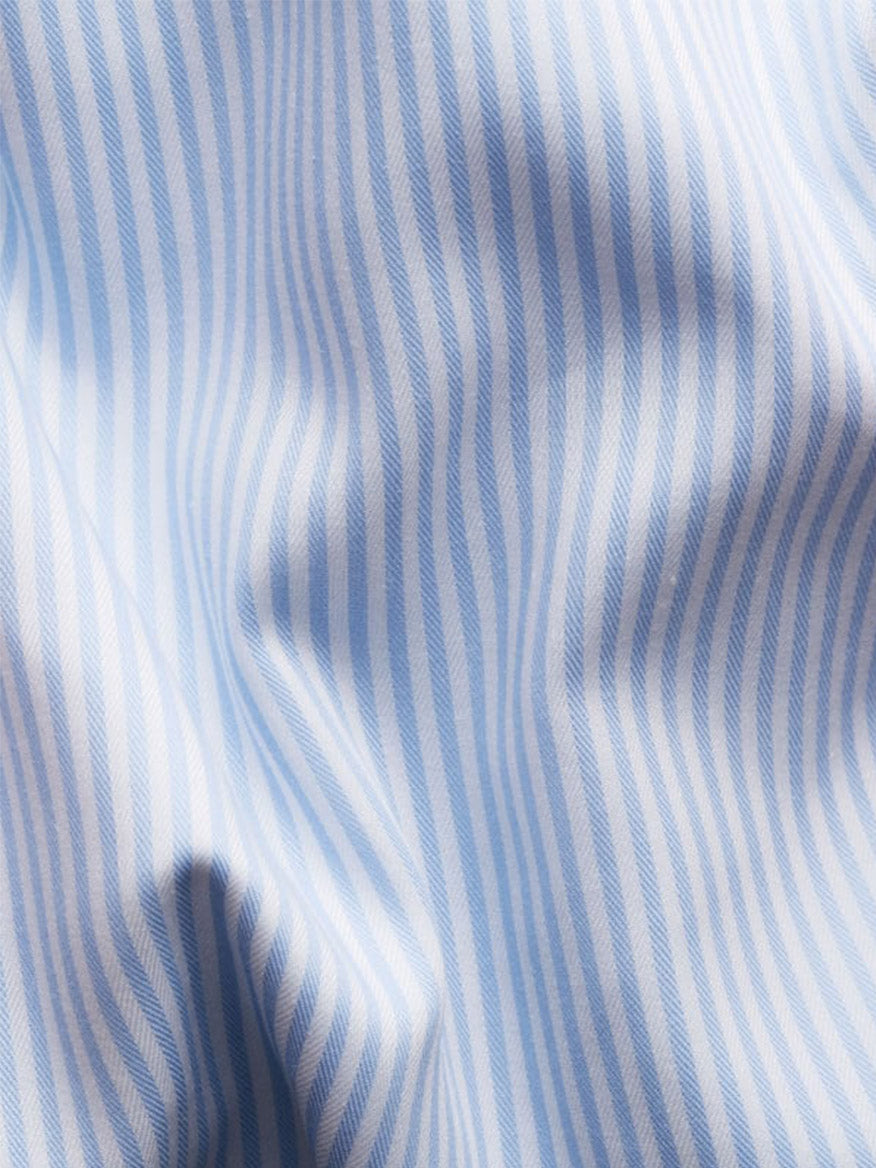 Close-up of light blue and white stripes with soft folds highlights the refined texture of the Eton Slim Fit Striped Fine Twill Dress Shirt in Light Blue, featuring an Extreme Cut Away Collar.