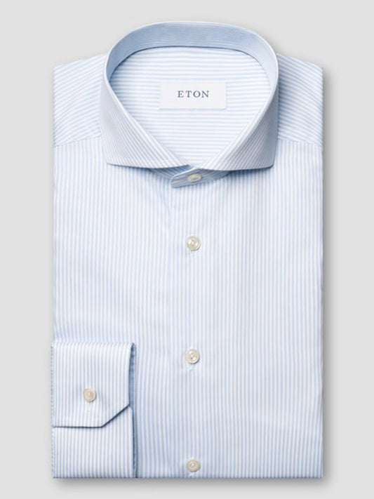 A neatly folded Eton Slim Fit Striped Fine Twill Dress Shirt in light blue with white stripes, featuring an extreme cut away collar and button cuffs, labeled “ETON” inside the collar.