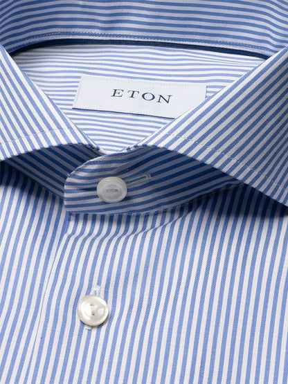 Close-up of an Eton Slim Fit Striped Fine Twill Dress Shirt in mid blue with white buttons, extreme cut away collar, and "ETON" label inside.