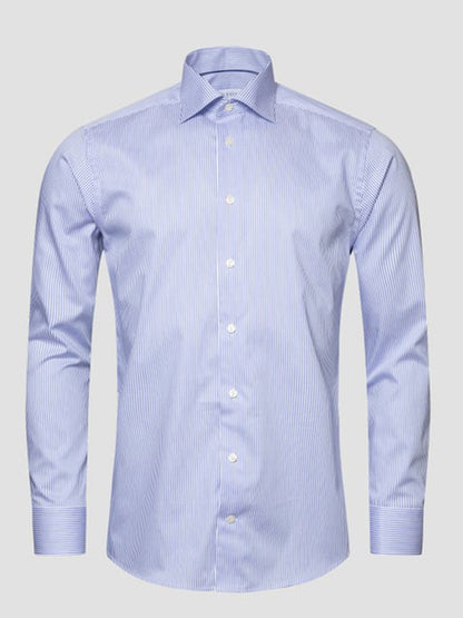 The Eton Slim Fit Striped Fine Twill Dress Shirt in Mid Blue features a cut away collar, long sleeves, and a subtle vertical pinstripe pattern, shown against a plain background.