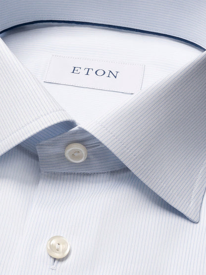 Close-up of the Eton Contemporary Fit Striped Twill Dress Shirt in light blue, featuring a pointed collar, white buttons, and crease-resistant cotton twill for a sharp look all day.