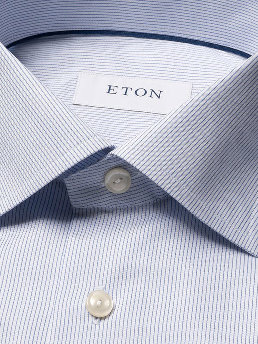 Close-up of the Eton Contemporary Fit Striped Twill Dress Shirt in Dark Blue, featuring thin dark blue stripes on light blue cotton, white buttons, and an Eton label—a timeless business staple.