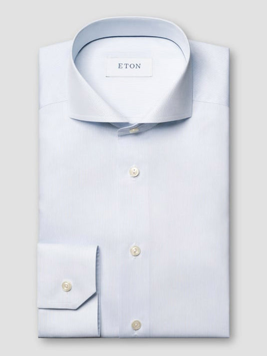 A light blue Eton Slim Fit Striped Twill Dress Shirt is neatly folded, featuring a spread collar, buttoned cuffs, and pearl-colored buttons against a plain background.