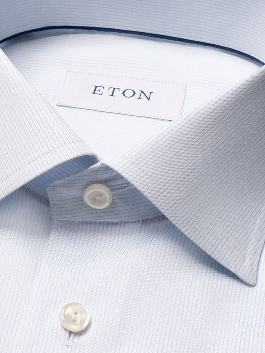 Close-up of the Eton Slim Fit Striped Twill Dress Shirt in Light Blue, crafted from crease-resistant cotton, showcasing its pinstripes, collar, buttons, and signature brand label.