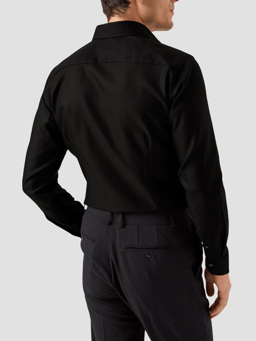 Man wearing an Eton Slim Fit Black Textured Twill Dress Shirt and dark dress pants, shown from the back against a plain light gray background.