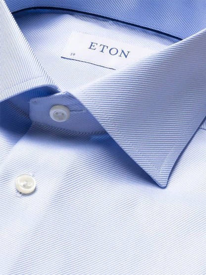Close-up of the Eton Slim Fit Solid Textured Twill Dress Shirt in Light Blue, highlighting the collar, two buttons, and brand label inside the neck.