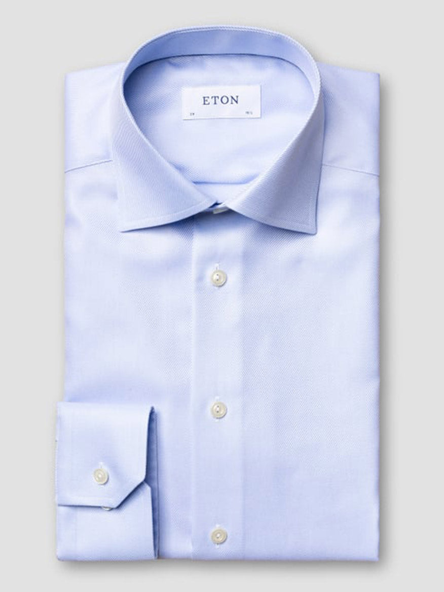 The Eton Slim Fit Solid Textured Twill Dress Shirt in Light Blue features a neat fold, white buttons, and a visible "ETON" label inside the collar, showcased against a plain background.