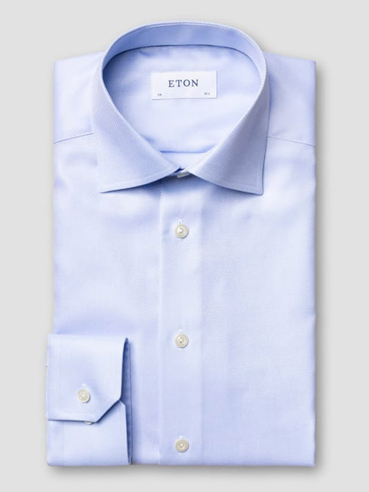 The Eton Slim Fit Light Blue Textured Twill Dress Shirt is neatly folded, showing its collar label.