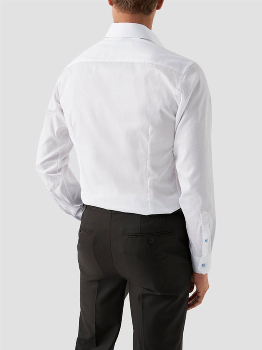 A man shown from the back is wearing an Eton Slim Fit Signature Twill Dress Shirt in white with blue details and black dress pants against a plain light gray background.