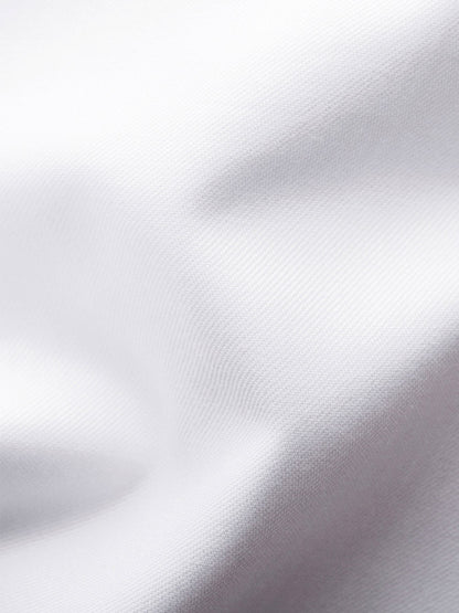 Close-up of the Eton Slim Fit Solid Signature Twill Dress Shirt in white with navy details, highlighting its textured organic cotton fabric and soft folds.