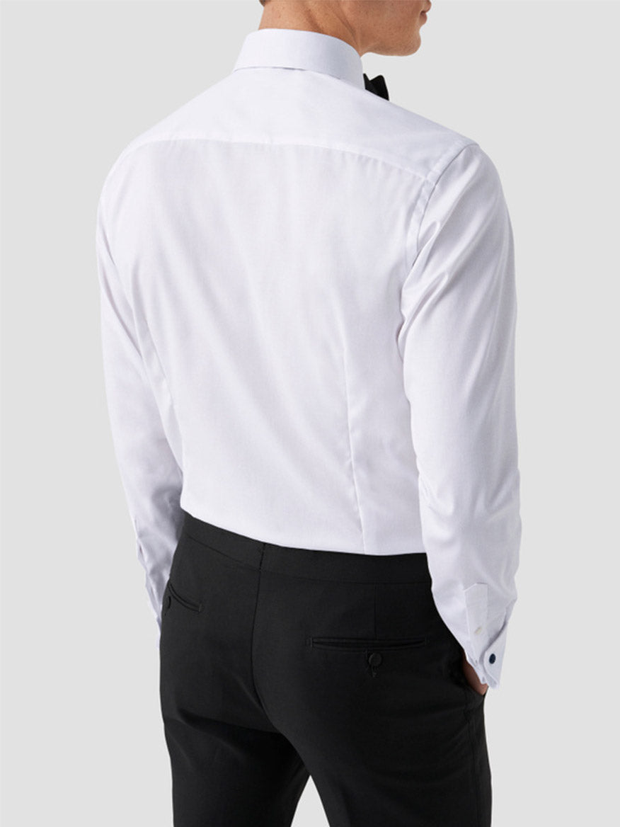 A man is seen from behind wearing the Eton Slim Fit Fly Front Signature Twill Evening Shirt in White, black bow tie, and black dress pants against a plain light gray background, ideal for a classic black-tie ensemble.