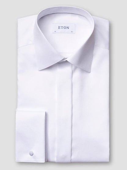 The Eton Contemporary Fit White Dobby Formal Shirt features French cuffs and a pointed collar, neatly folded with the "ETON" label visible inside the neckline, set against a plain light gray background.
