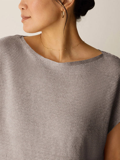 A woman wearing the Eileen Fisher Organic Linen Délavé Square Top in Walnut, styled with a gold necklace and hoop earring, looks to the side.