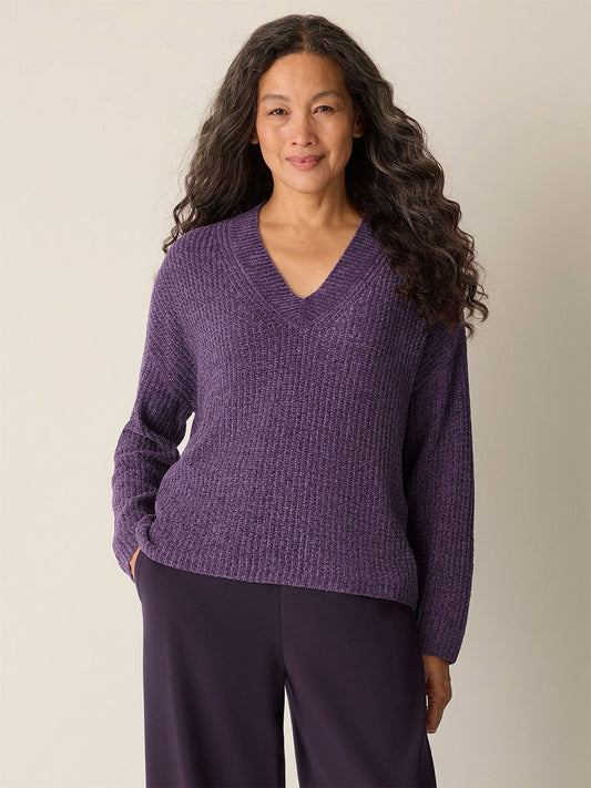 A woman with long hair is wearing the Eileen Fisher Chenille Blend V-Neck Top in Mulled Grape and matching pants.