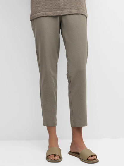 Person wearing Eileen Fisher Washable Stretch Crepe Pant in Dove and matching slides, with legs and lower torso visible.