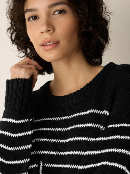 Woman with short curly hair wearing the Eileen Fisher Peruvian Organic Cotton Cord Crew Neck Top in Black/White, looking at the camera with a neutral expression.