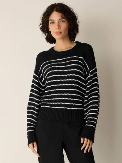 A person wearing the Eileen Fisher Peruvian Organic Cotton Cord Crew Neck Top in Black/White and black pants stands against a plain light-colored background.