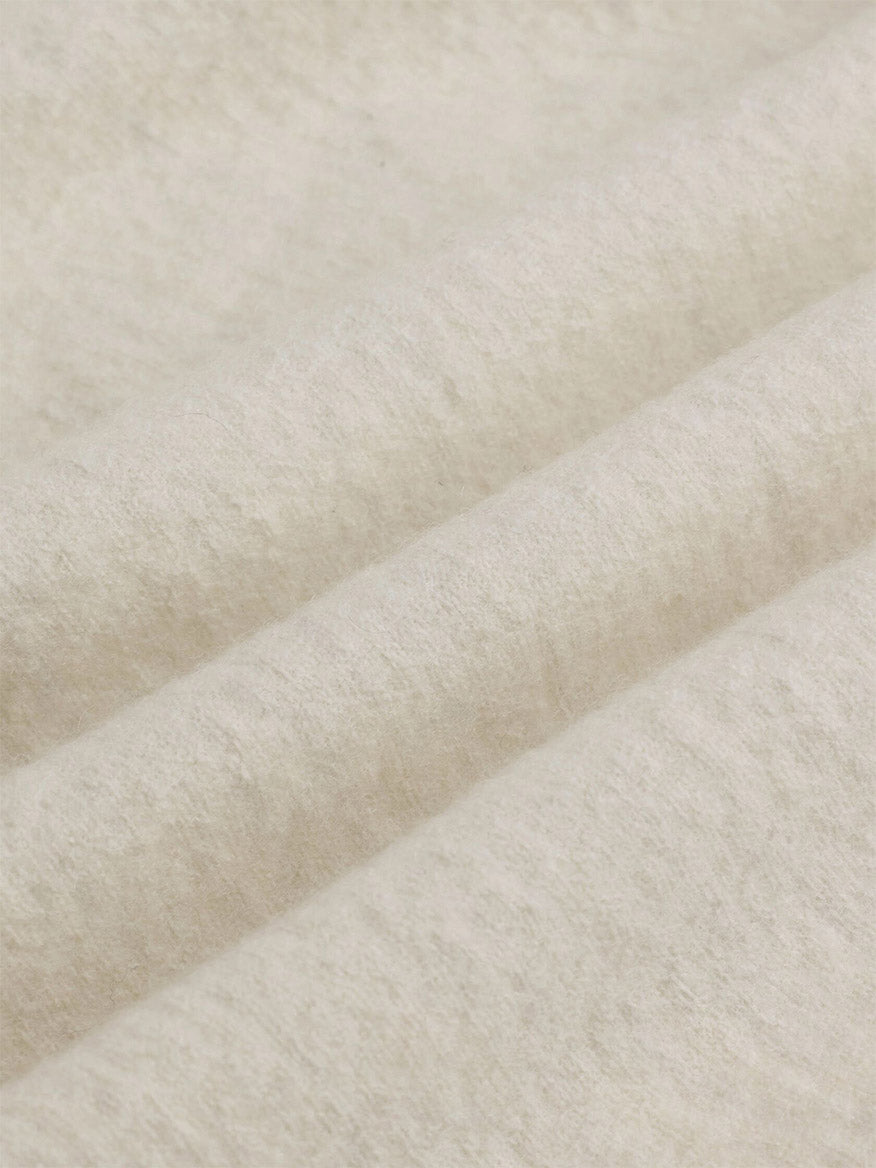 Close-up of an Eileen Fisher Fine Felted Wool Hooded Cardigan in Regenerative Wool in Plaster, featuring off-white felted fabric with soft folds.