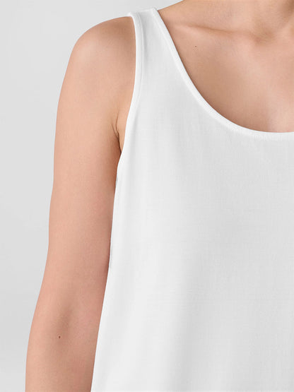 A close-up shows a person wearing the Eileen Fisher Fine Jersey Scoop Neck Tank in White, highlighting the upper chest, shoulder, and upper arm against a plain light background.