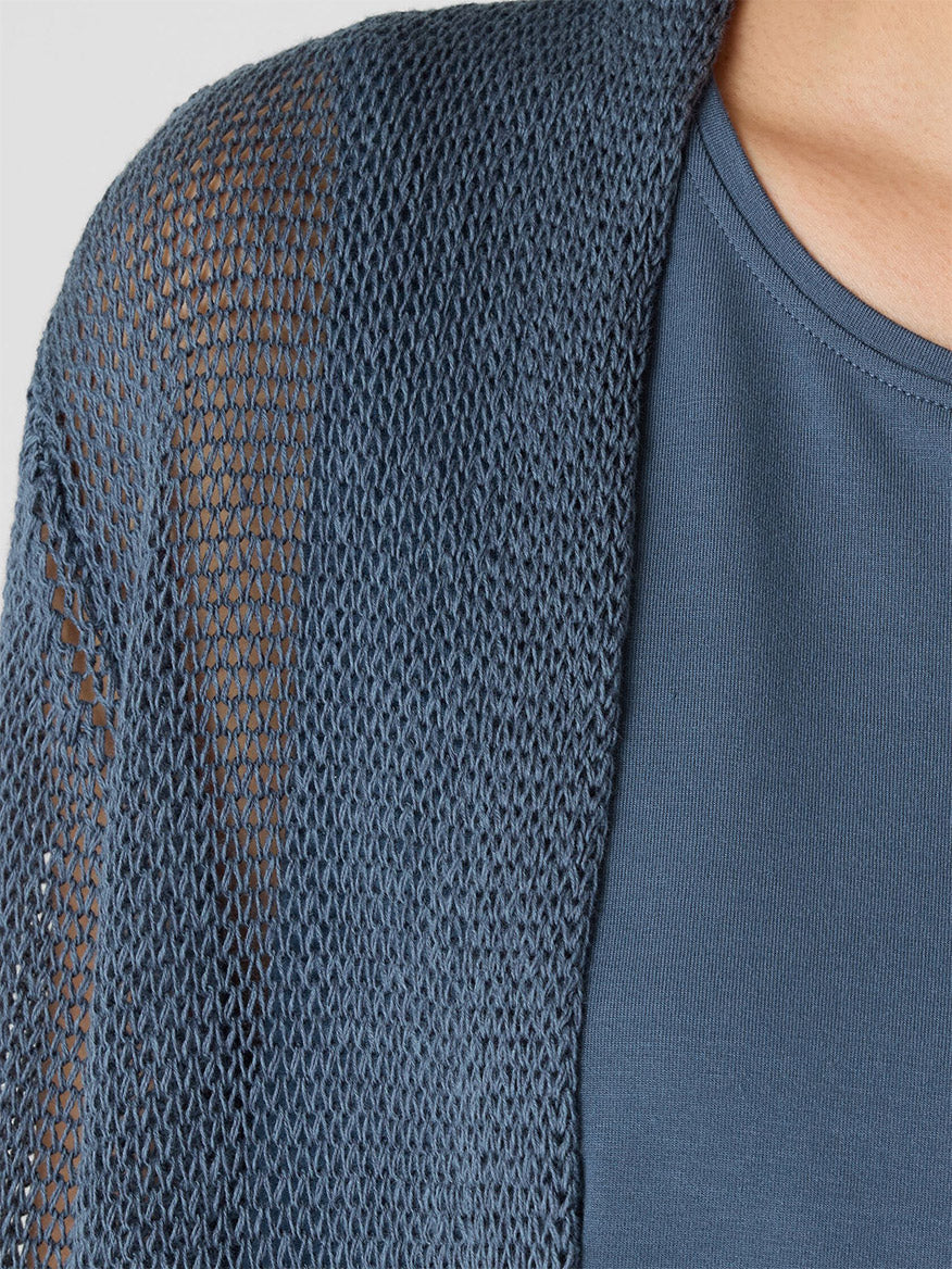 Close-up of a person wearing the Eileen Fisher Organic Linen Cotton Cord Long Cardigan in Eclipse over a matching blue shirt.