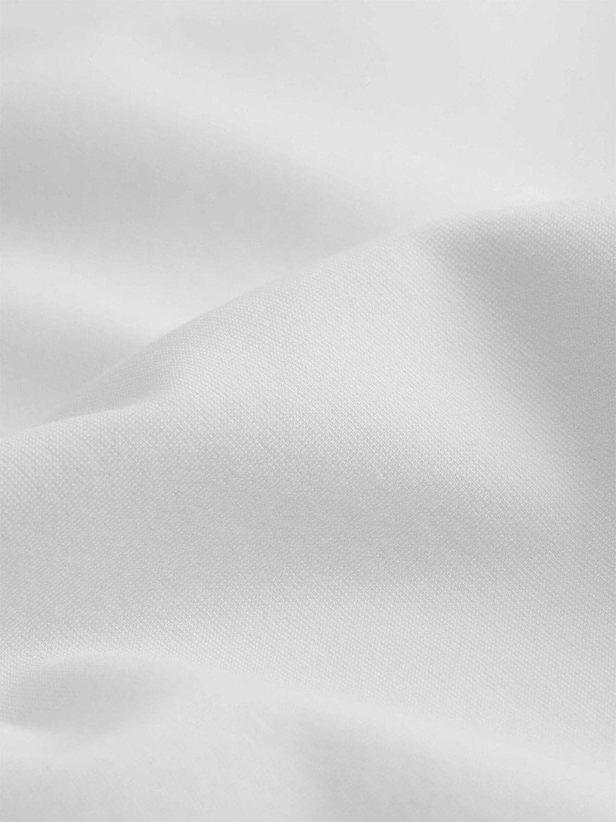 Close-up of the extra-fine, smooth white fabric with gentle folds and soft shadows, characteristic of the Eileen Fisher Extra-Fine Ponte Crew Neck Tee in White.
