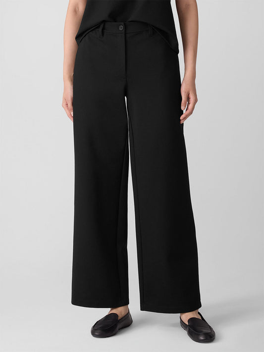 Wearing the Eileen Fisher Washable Flex Ponte Wide Trouser Pant in Black with a matching top and flats—an effortlessly stylish pick for fall, Fair Trade Certified and perfect against a simple, light backdrop.